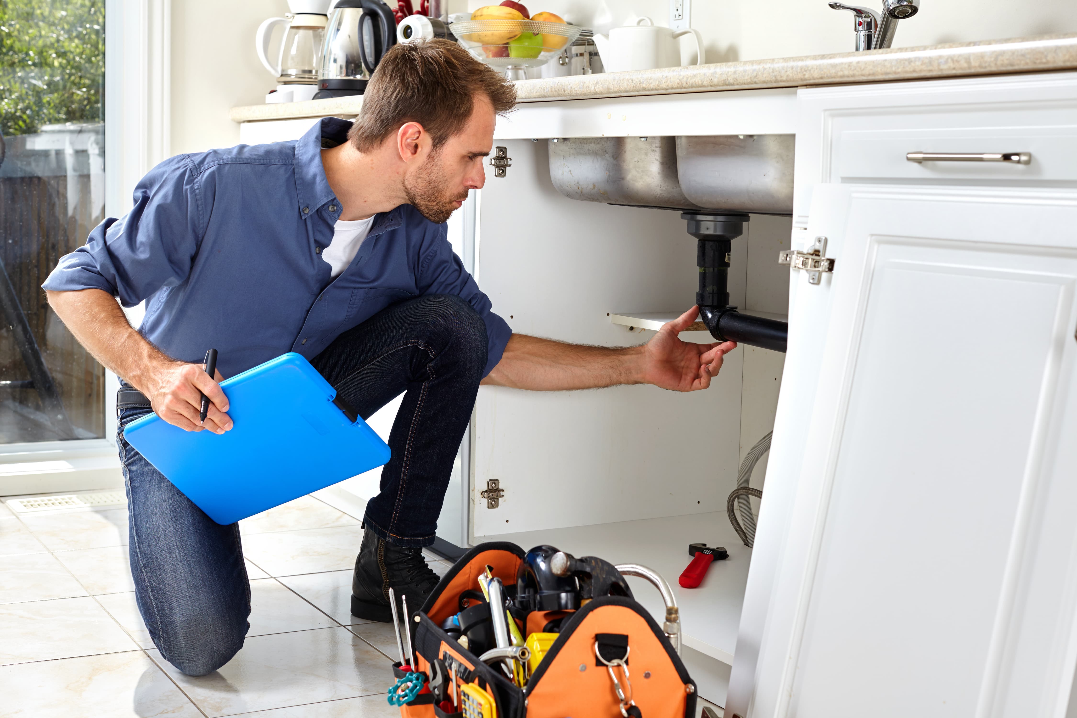 Plumber looking at a pipe.